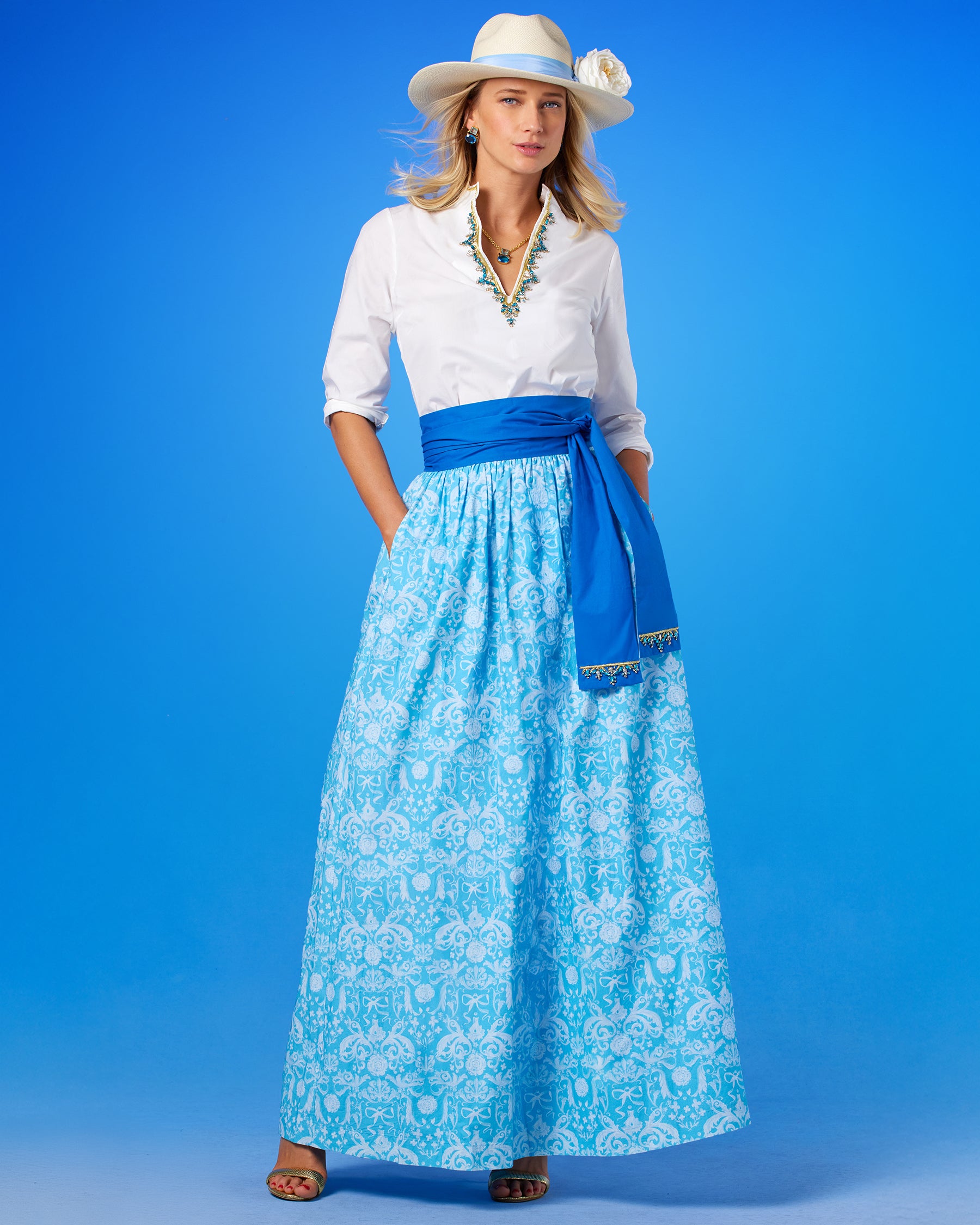 Alexandra Long Full Skirt in Porcelain Regency Ribbons worn with the Circe Tunic in Pure White with Crystals and Gold Embellishment with theCirce Reversible Blue Sash Belt Embellished with Crystals and Gold