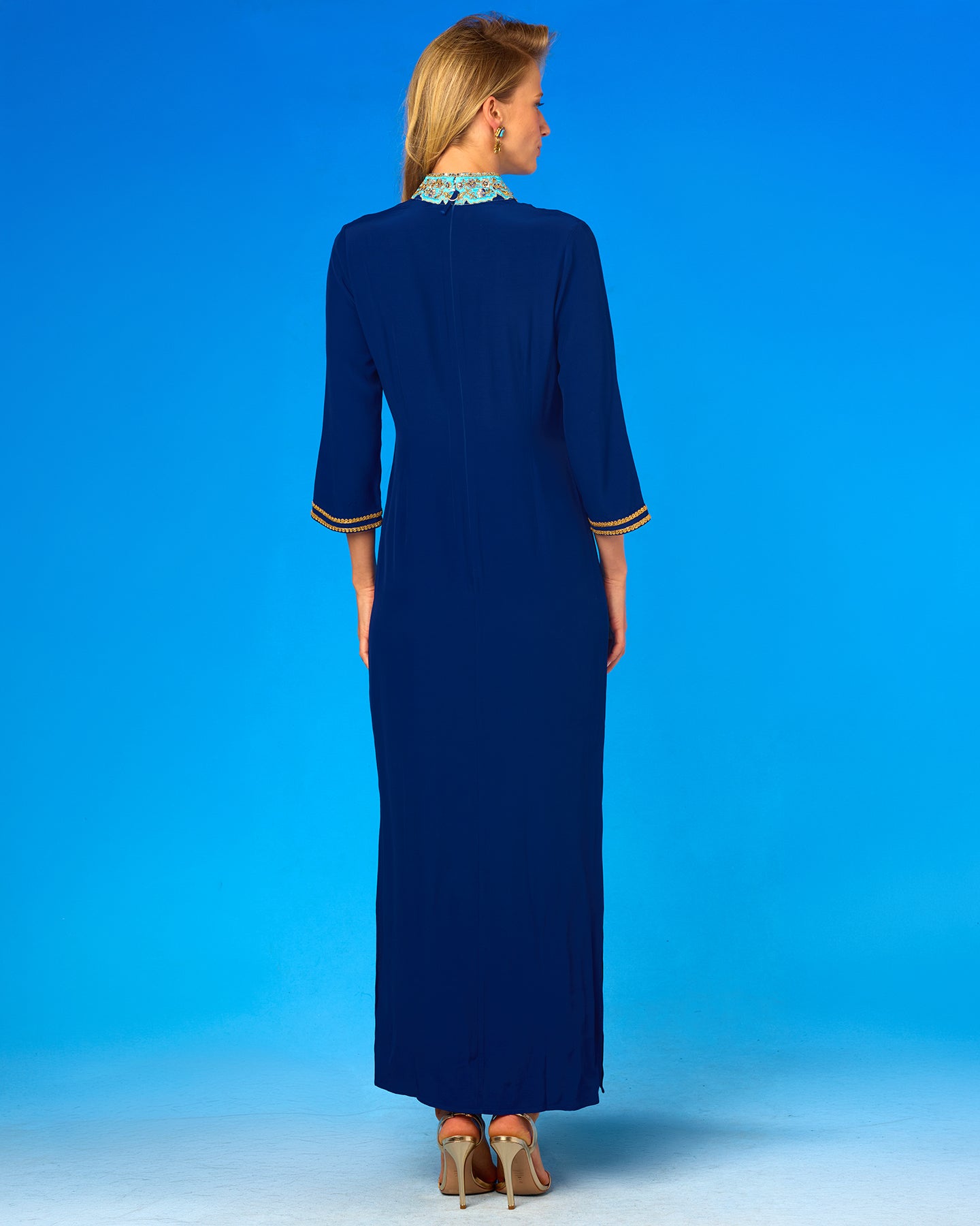 Woman wearing a long blue dress against a blue background