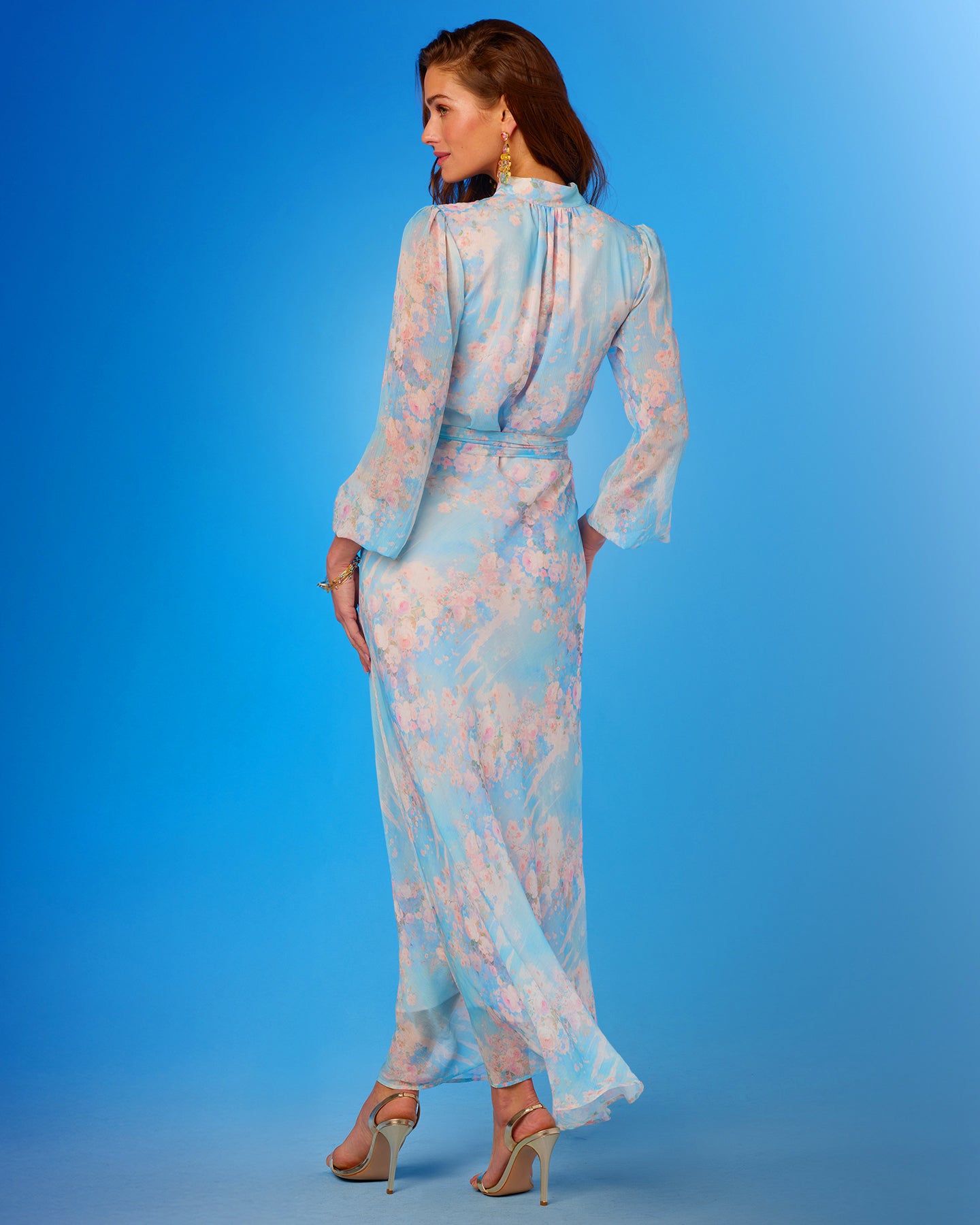 Woman wearing a light blue floral dress against a blue background