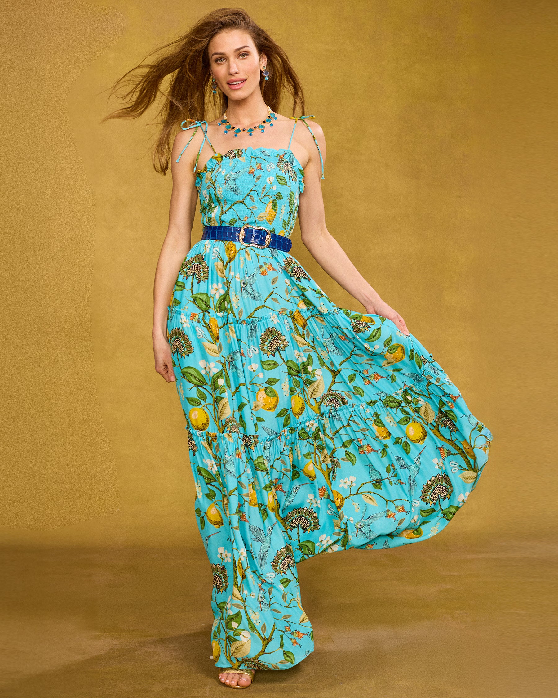 Annabelle Maxi Dress in Flora Turquoise Hummingbird Print front view walking with skirt flaring in the wind
