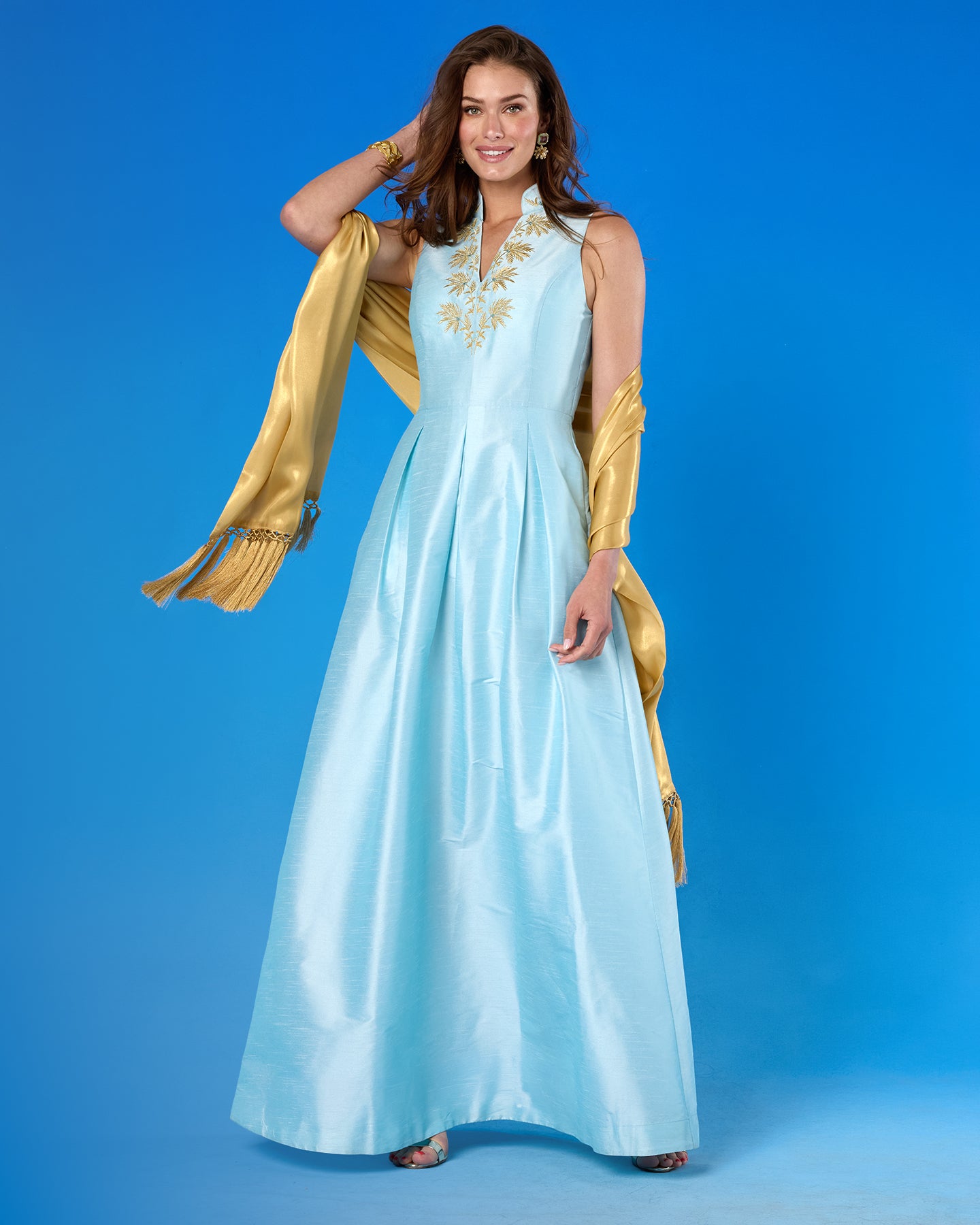 The Arabella Fringe Shawl in Pale Gold Shimmer worn with the Celestine Gown in Pastel Blue and Gold Palm Embroidery