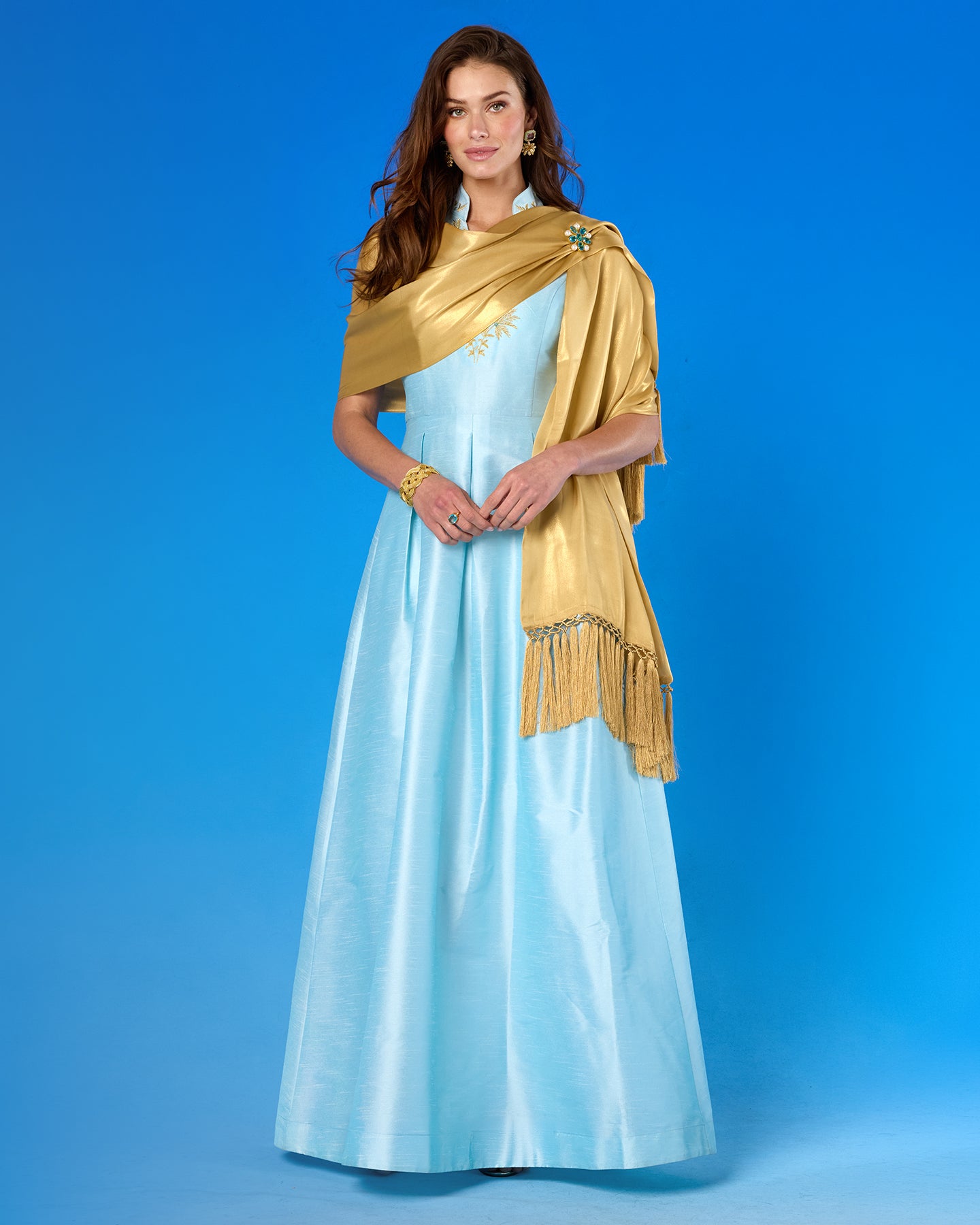 The Arabella Fringe Shawl in Pale Gold Shimmer worn with the Celestine Gown in Pastel Blue and Gold Palm Embroidery