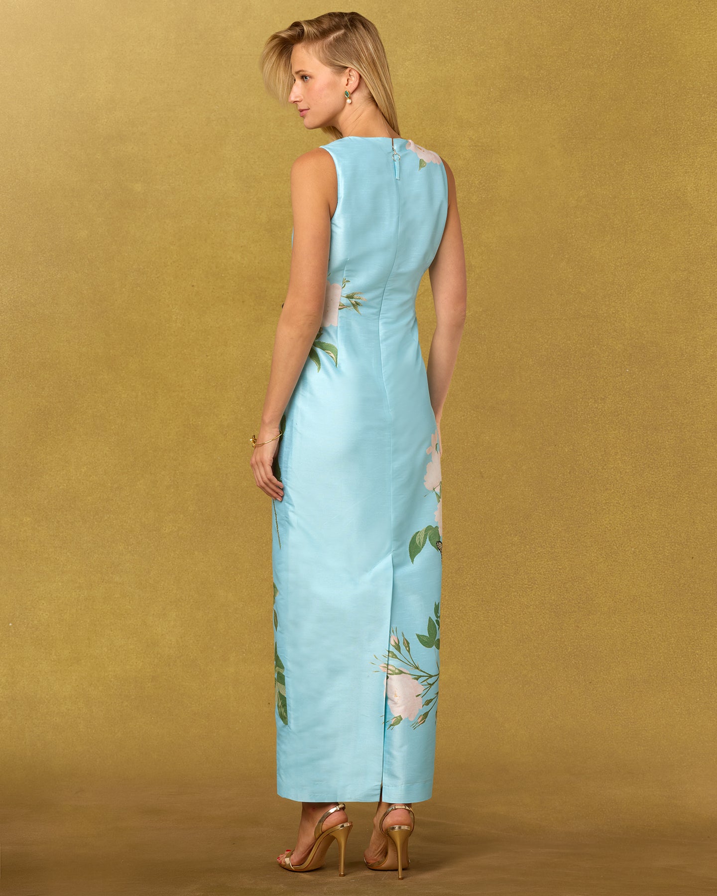 Woman wearing a light blue floral dress against a gold background