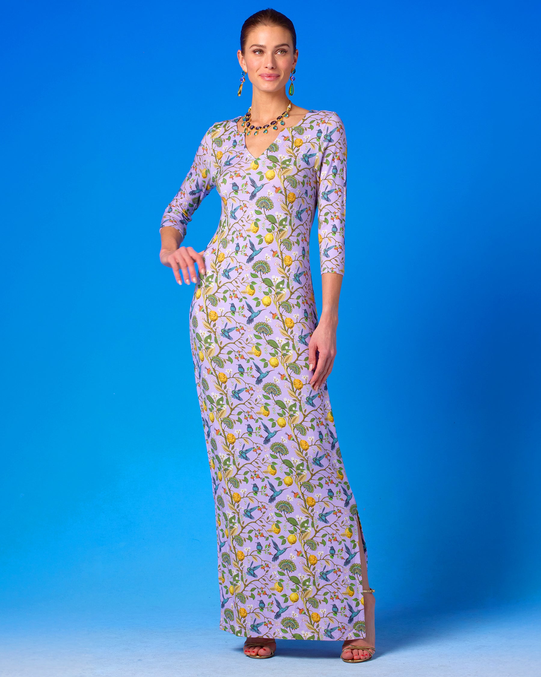 Flora Long Stretch Dress in Lavender Hummingbird Print arms on hip and looking away