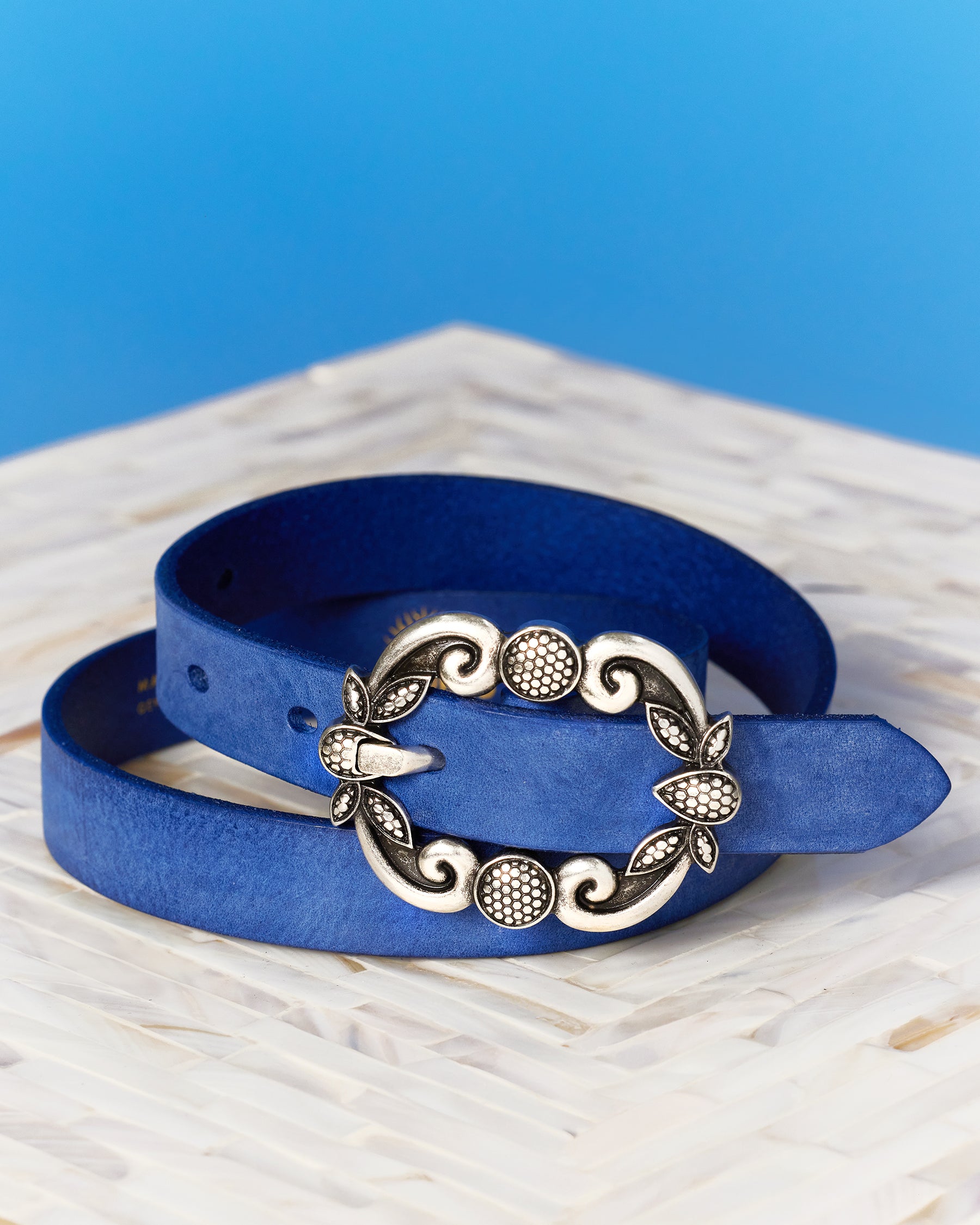 Harper Leather Belt in Indigo Blue rolled up and shown as a still life