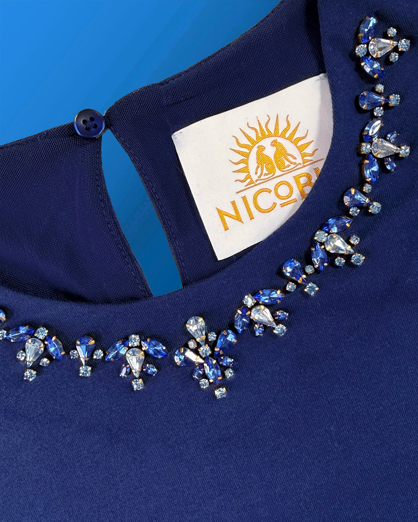 Detail of the jewel faceted stone embellishment on the collar of the Circe 3/4 Length Sleeve Tee in Navy