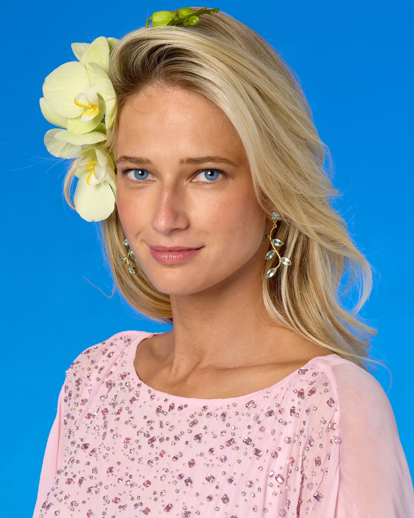 Woman with a flower in her hair against a blue background