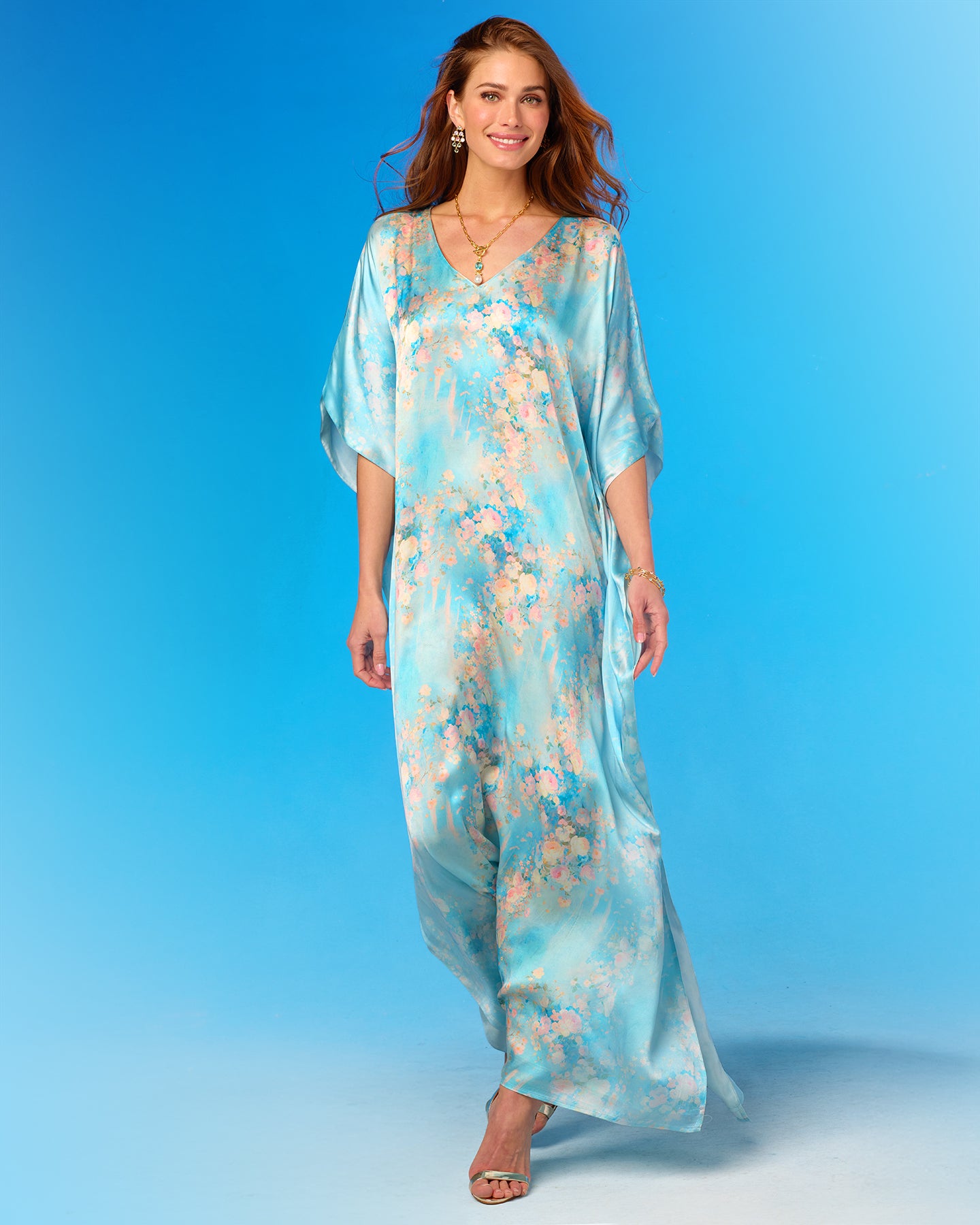 Woman wearing a floral caftan against a blue background