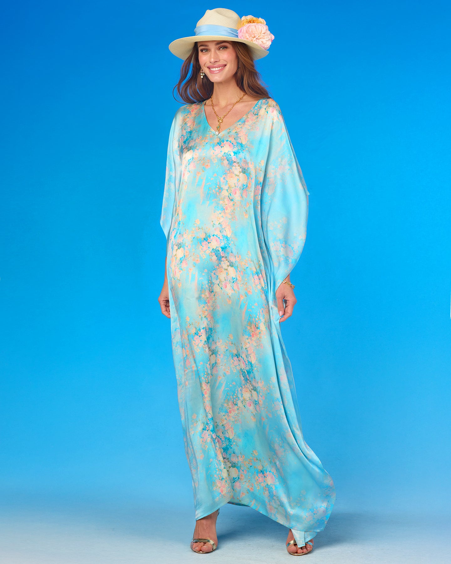 Woman wearing a floral dress and hat against a blue background