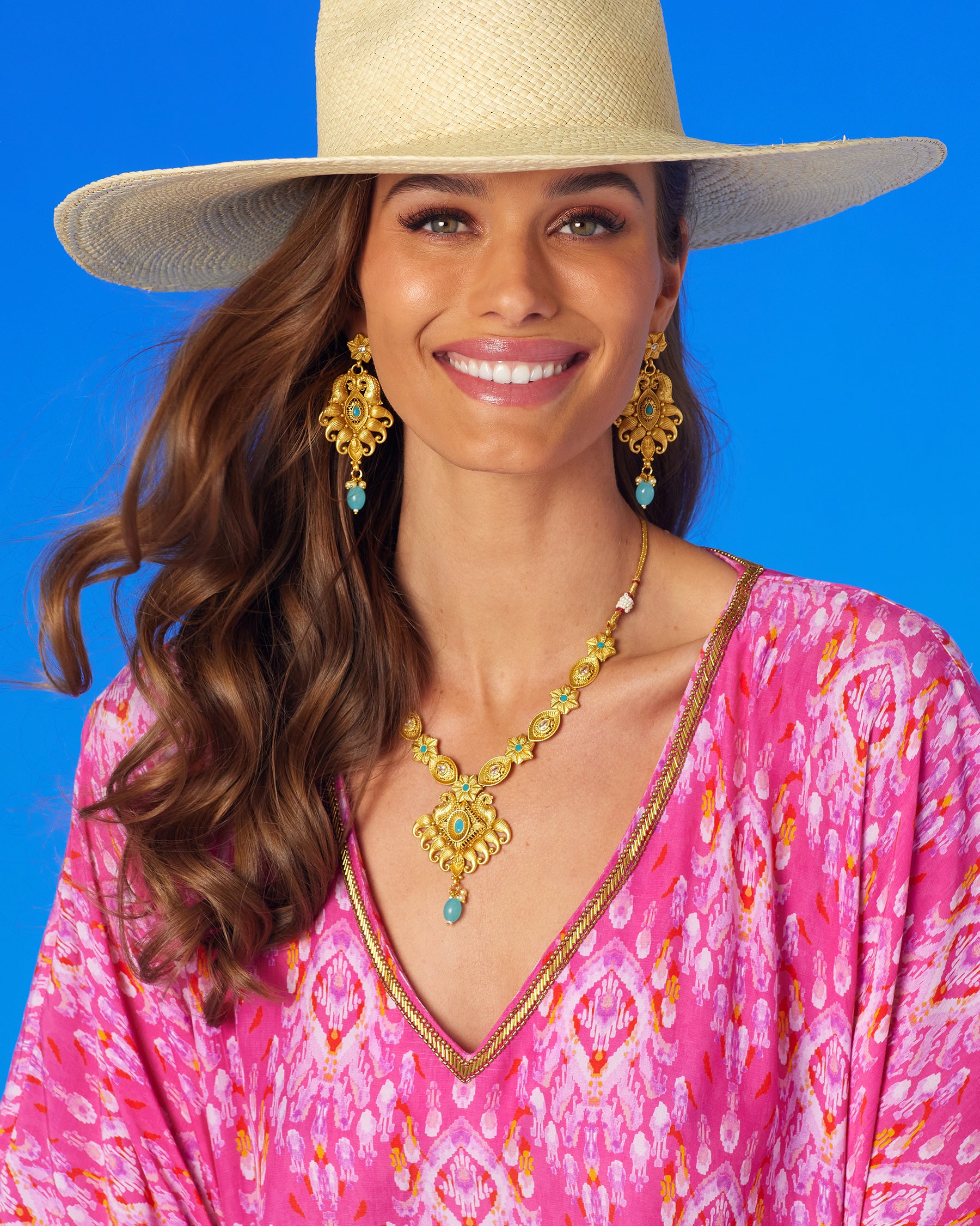 Aria Necklace in Gold Plated Filigree and Aquamarine worn with the Orchidea Kaftan in Fuchsia Pink Ikat and Gold Beaded Trim and straw hat