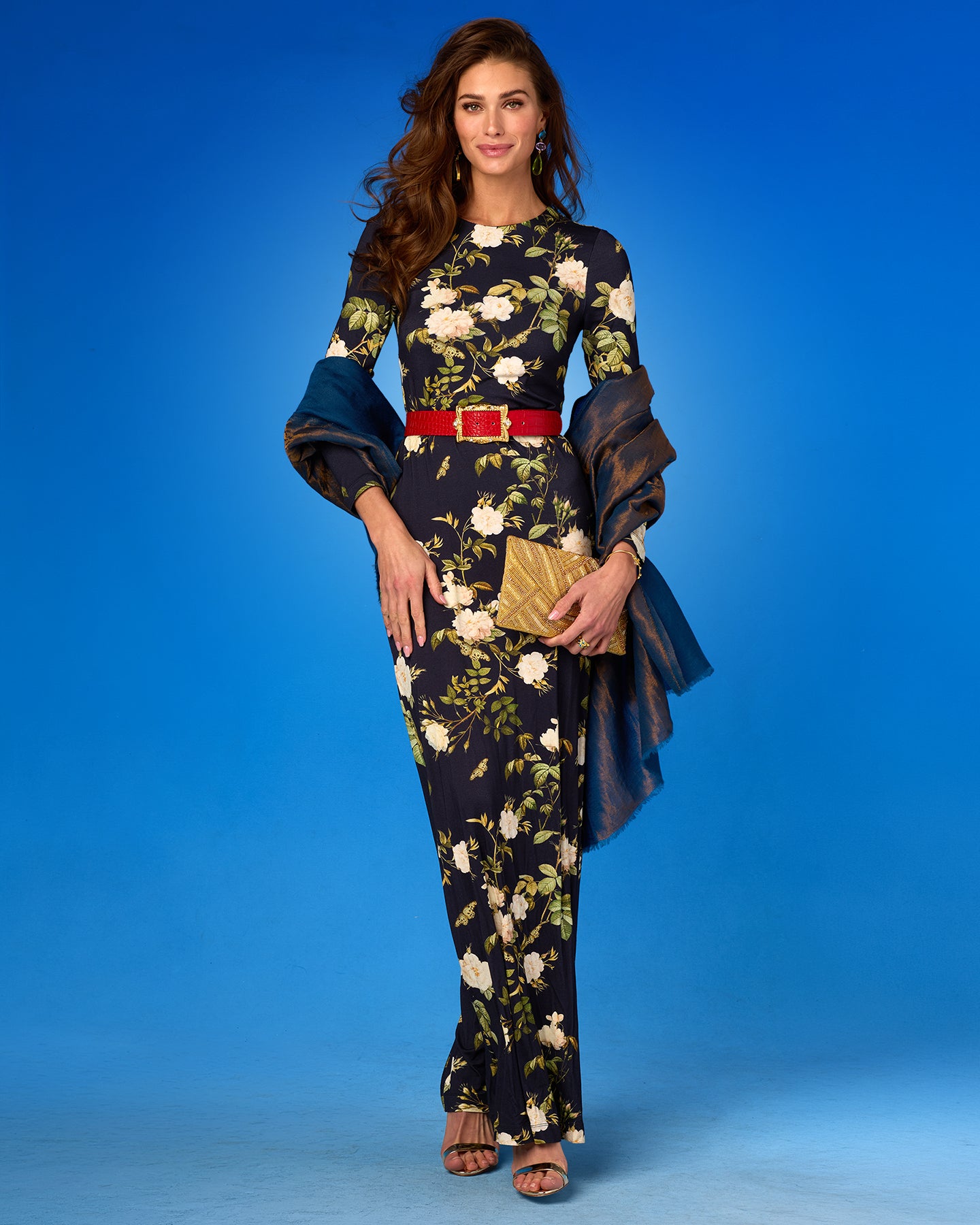 Woman wearing a floral dress with a red belt on a blue background