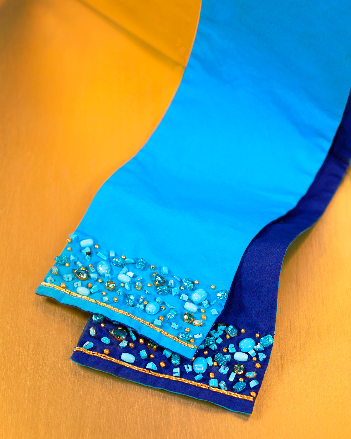 Celeste Reversible Belt in Brilliant Azure Embellished in Gold and Semiprecious Stones-closeup of hand embellishment