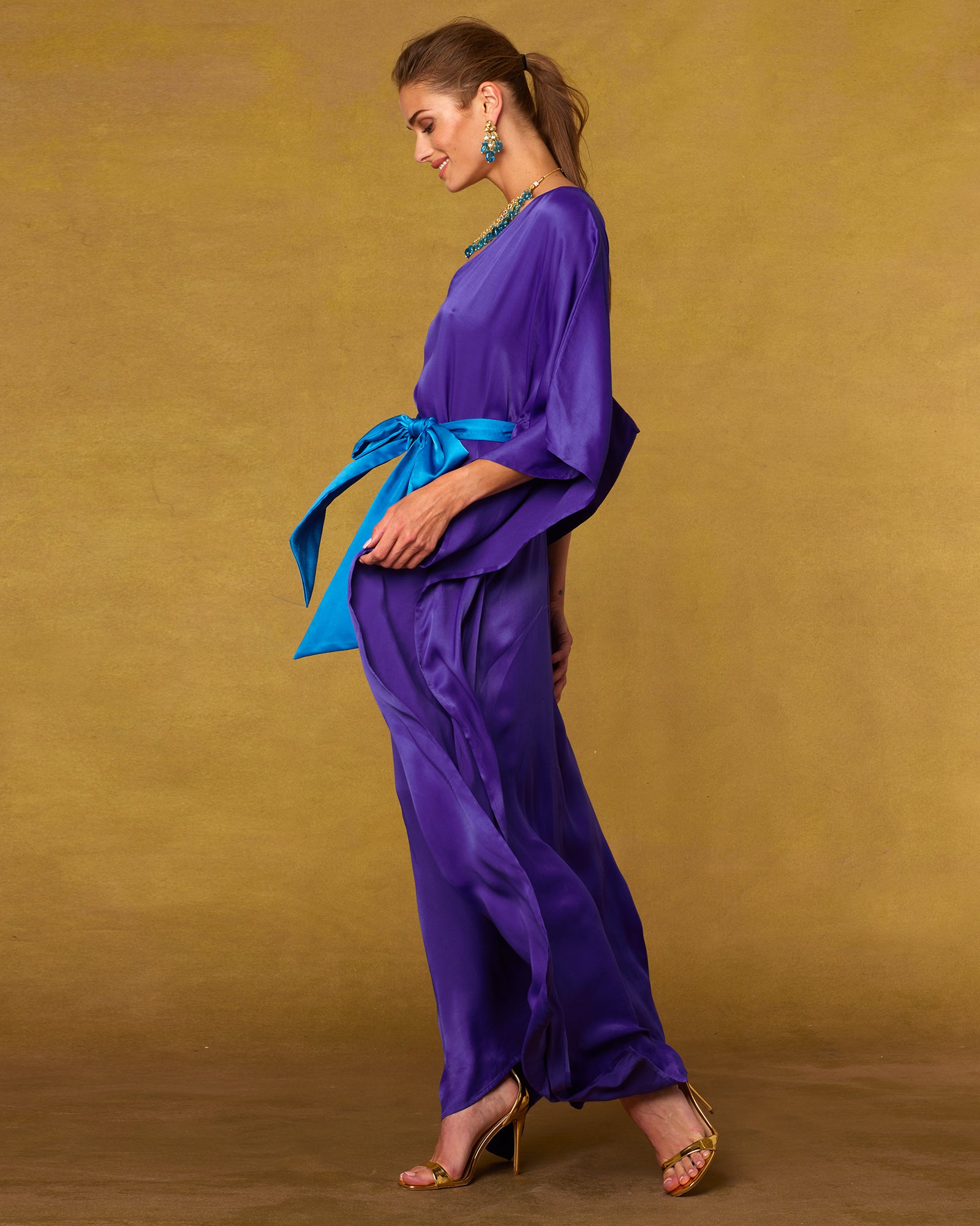 Side view of model wearing the Alessandra Belted Silk Kaftan in Royal Purple