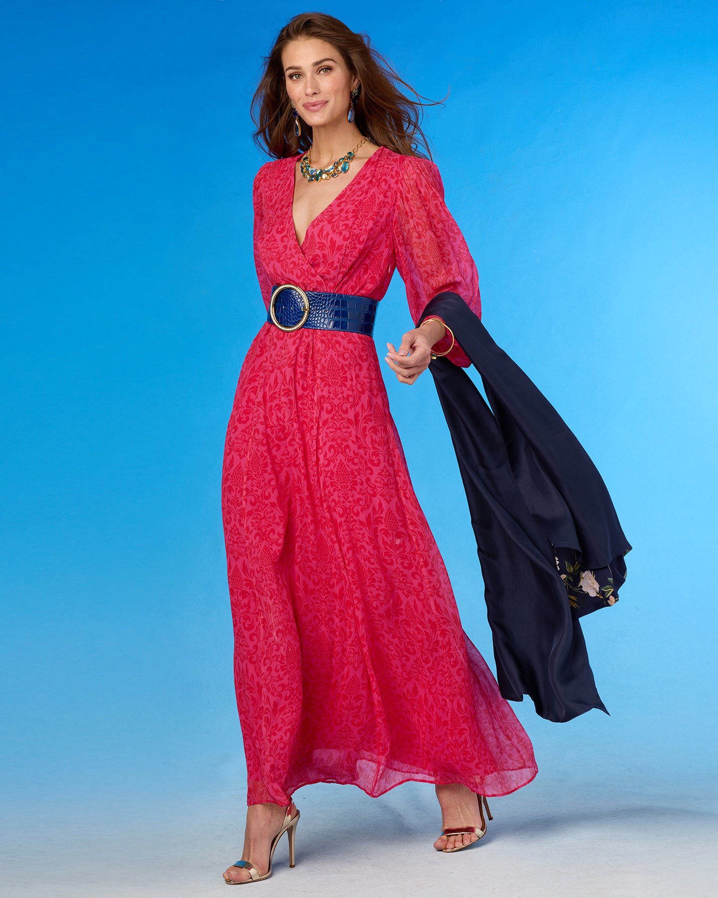 Woman in a red dress with a blue belt against a blue background