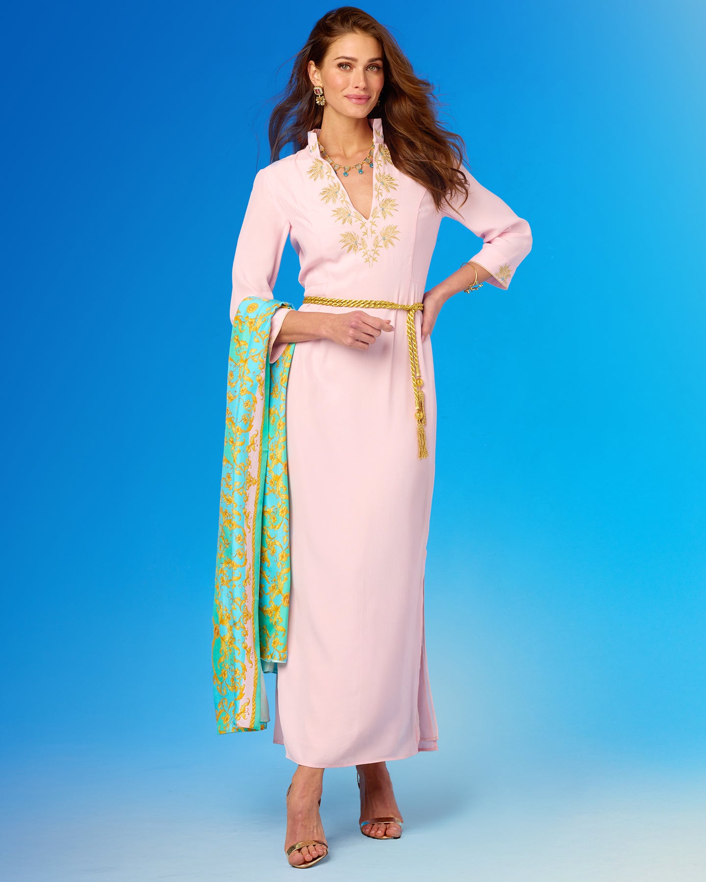 Woman wearing a pink dress with floral patterns on a blue background