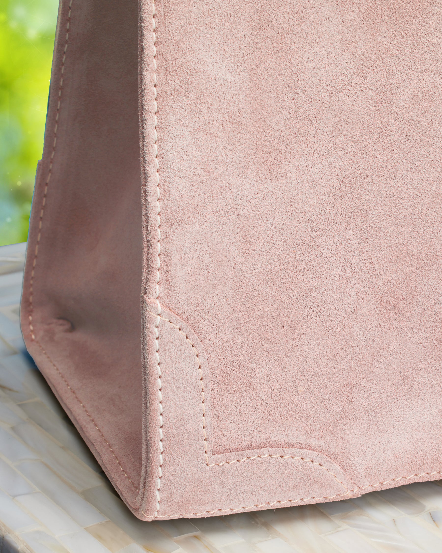 Closeup view of suede detail of the Marquise Paris Champs-Élysées Equestrian Top Handle Shoulder Bag in Soft Pink