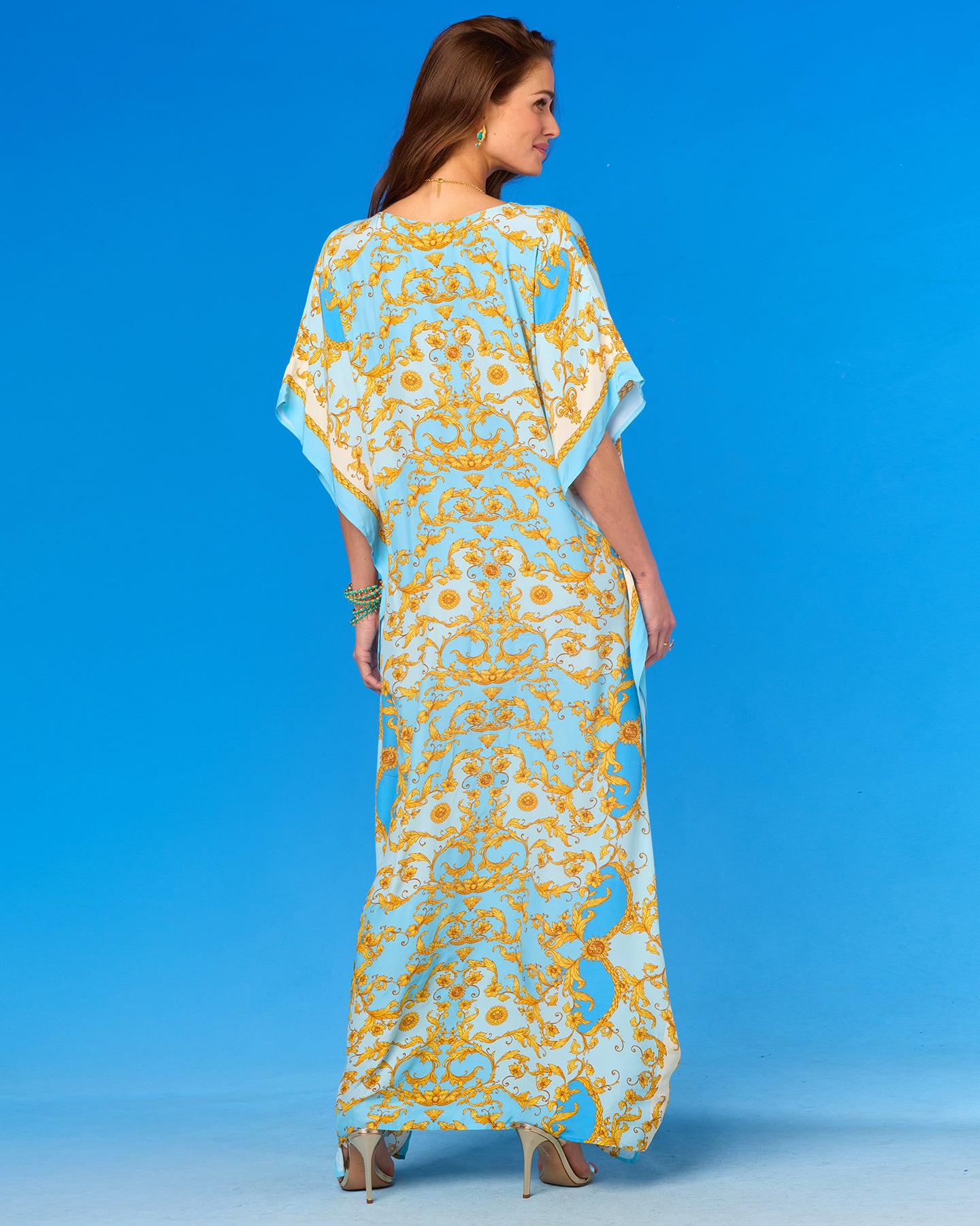 Woman wearing a blue and yellow patterned dress against a blue background