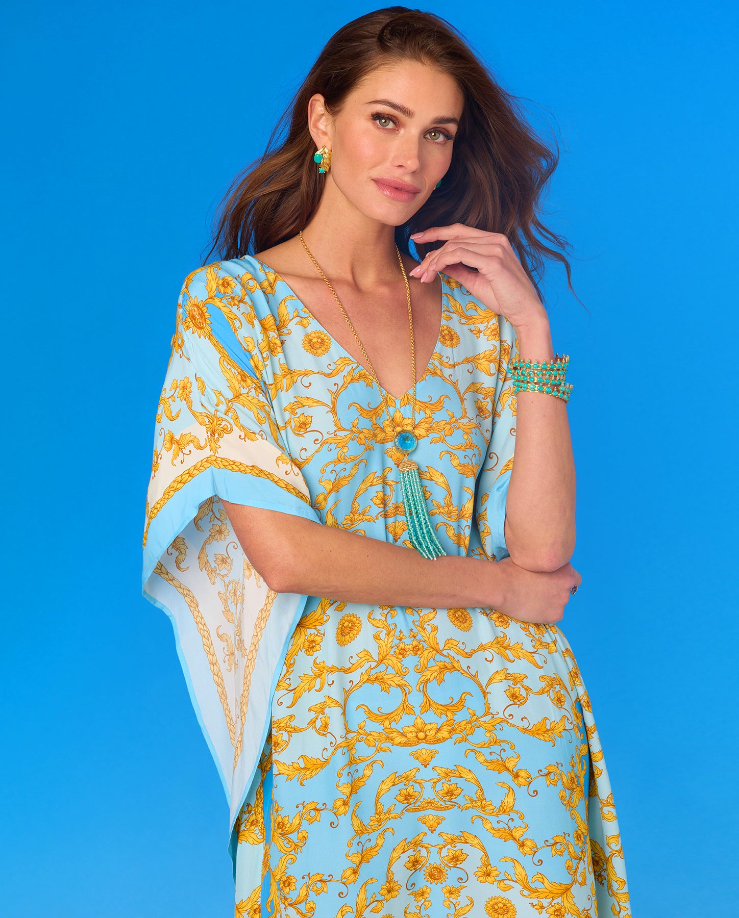 Woman wearing a blue and yellow patterned dress against a blue background