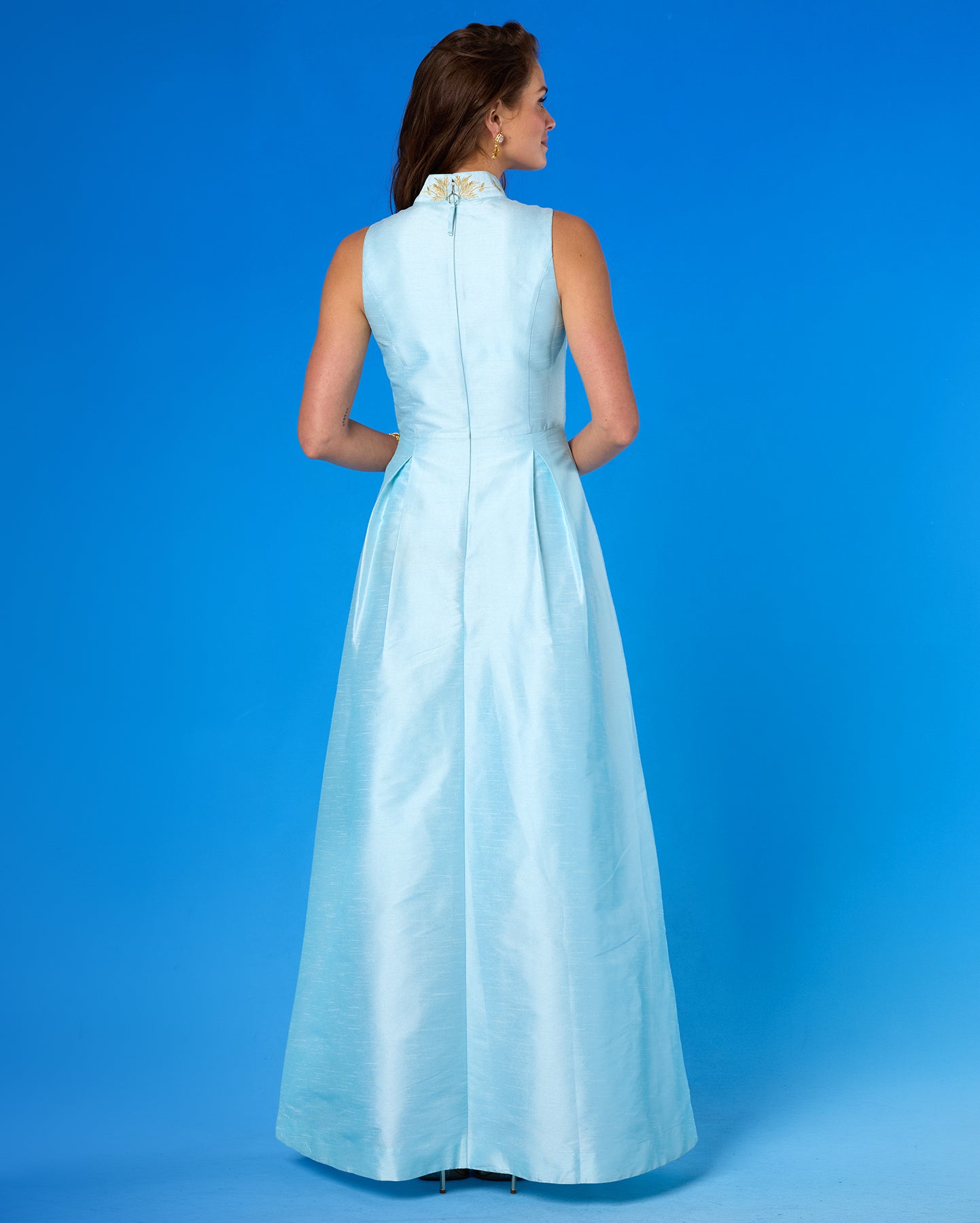Woman wearing a light blue evening gown against a blue background