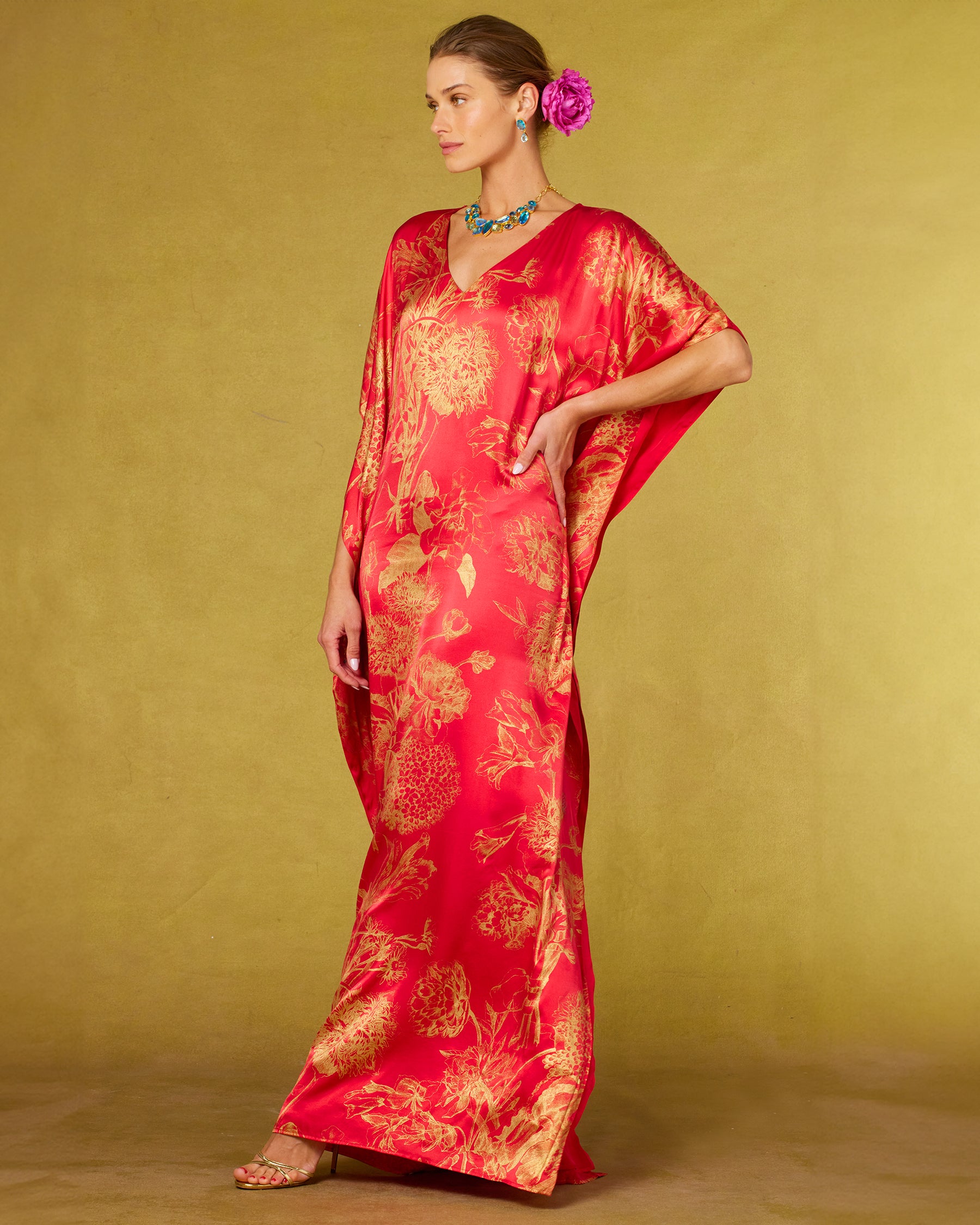 Chantal Red Silk Kaftan in Gold Floral Toile and hand on hip and model looking away