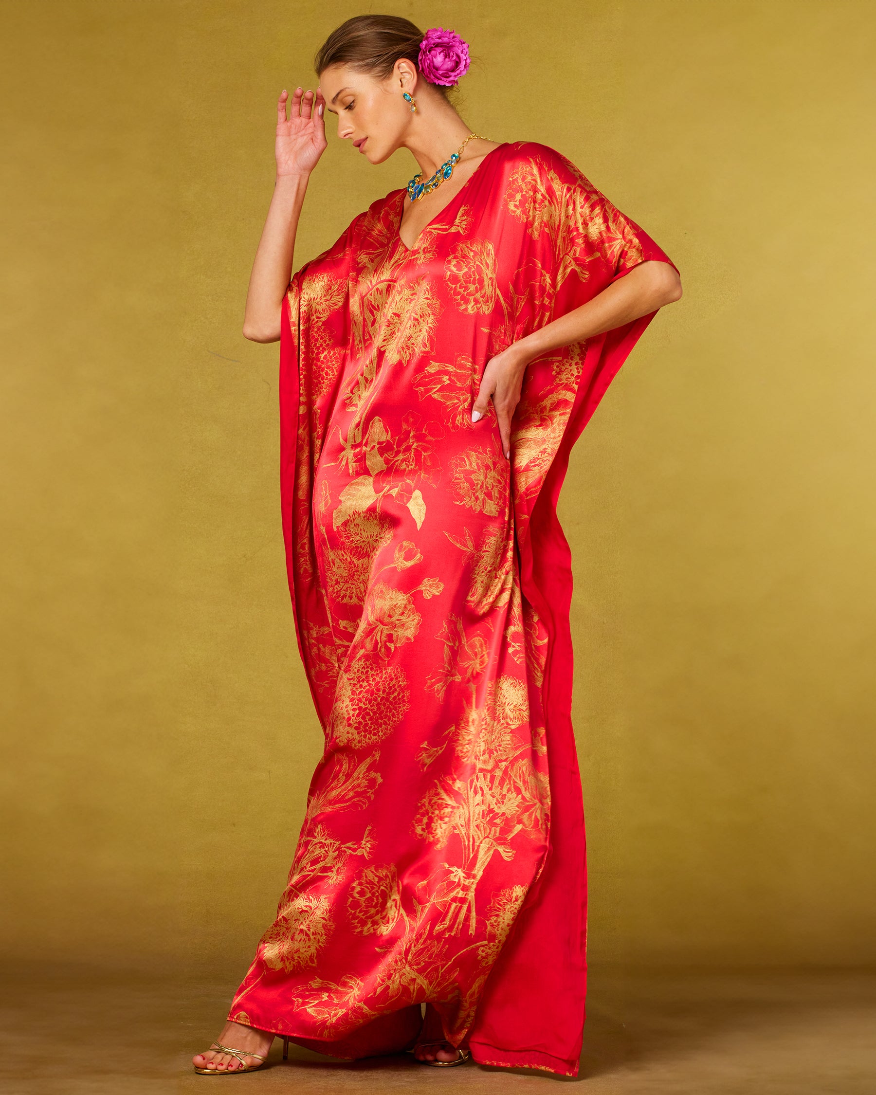 Chantal Red Silk Kaftan in Gold Floral Toile and hand on hip and model looking down