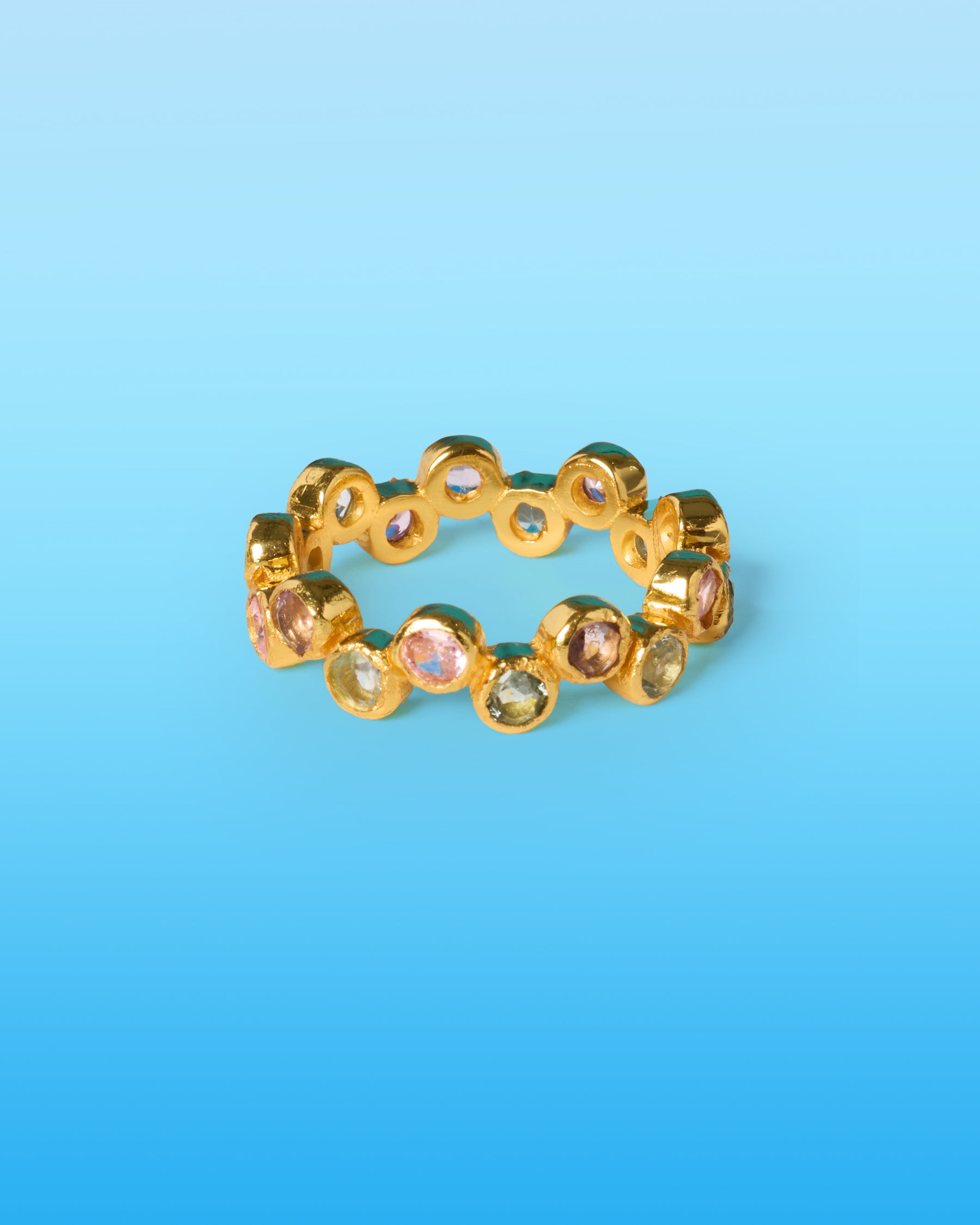 Gold ring with gemstones on a blue background