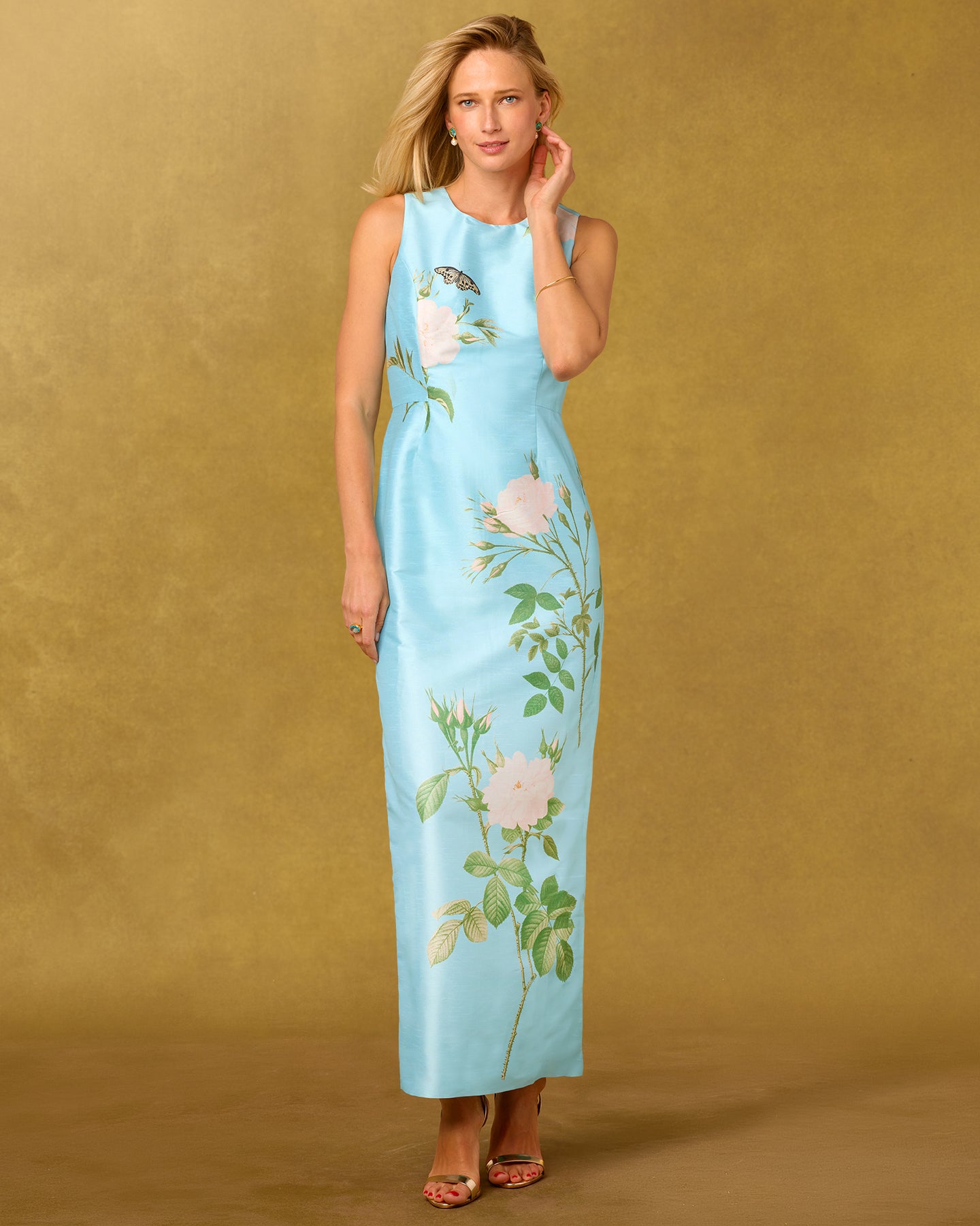 Woman wearing a light blue floral dress against a gold background