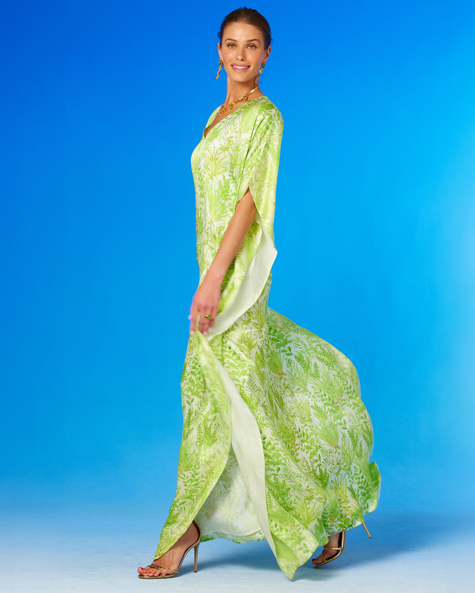 Eve Silk Kaftan in Delicate Greenery-side view with kaftan blowing in the wind