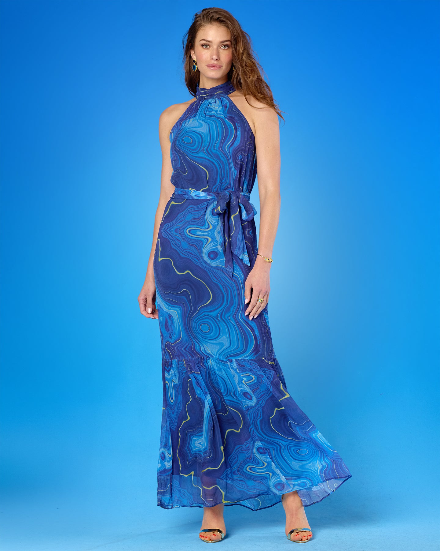 Woman wearing a blue patterned dress against a blue background