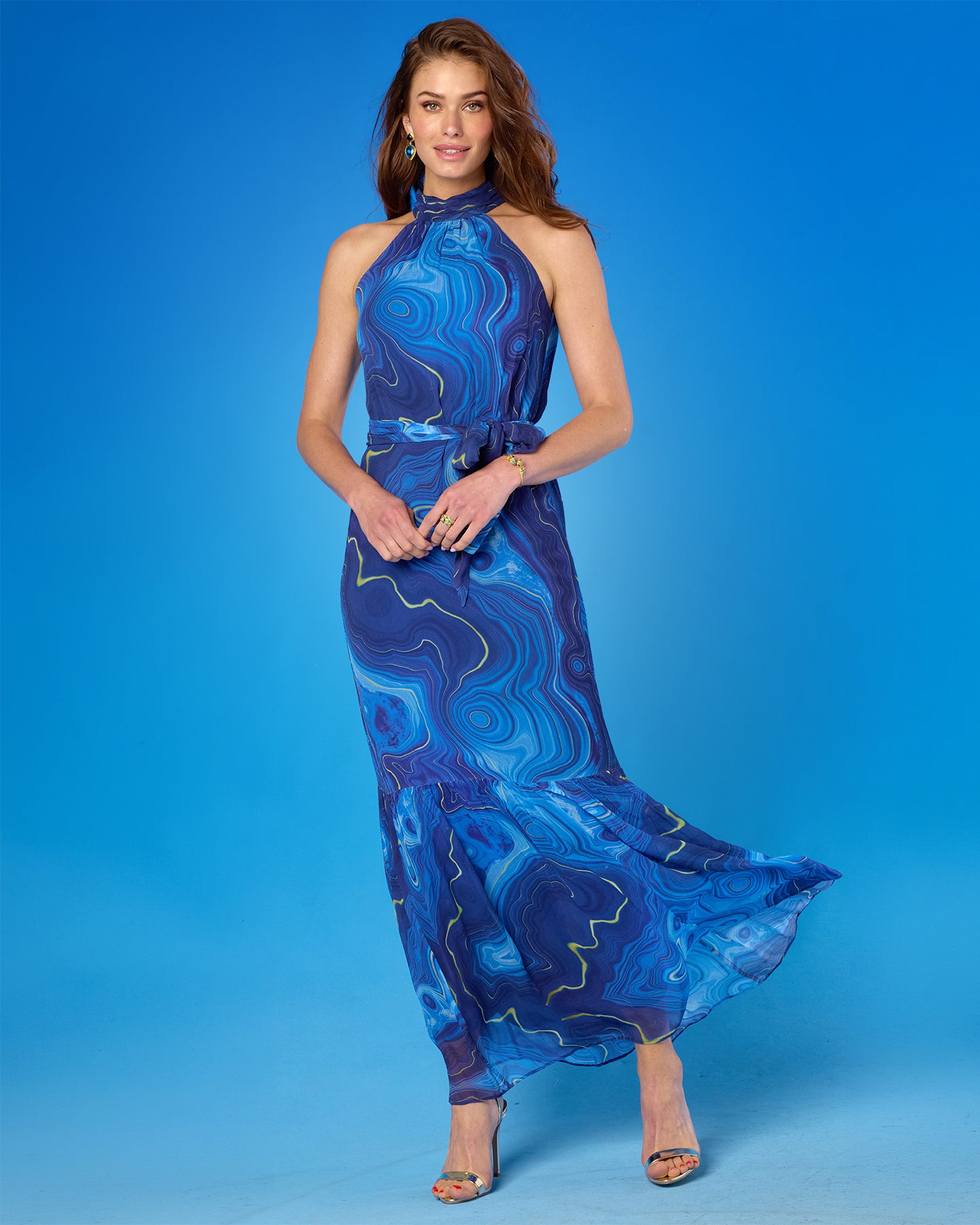 Woman wearing a blue patterned dress against a blue background