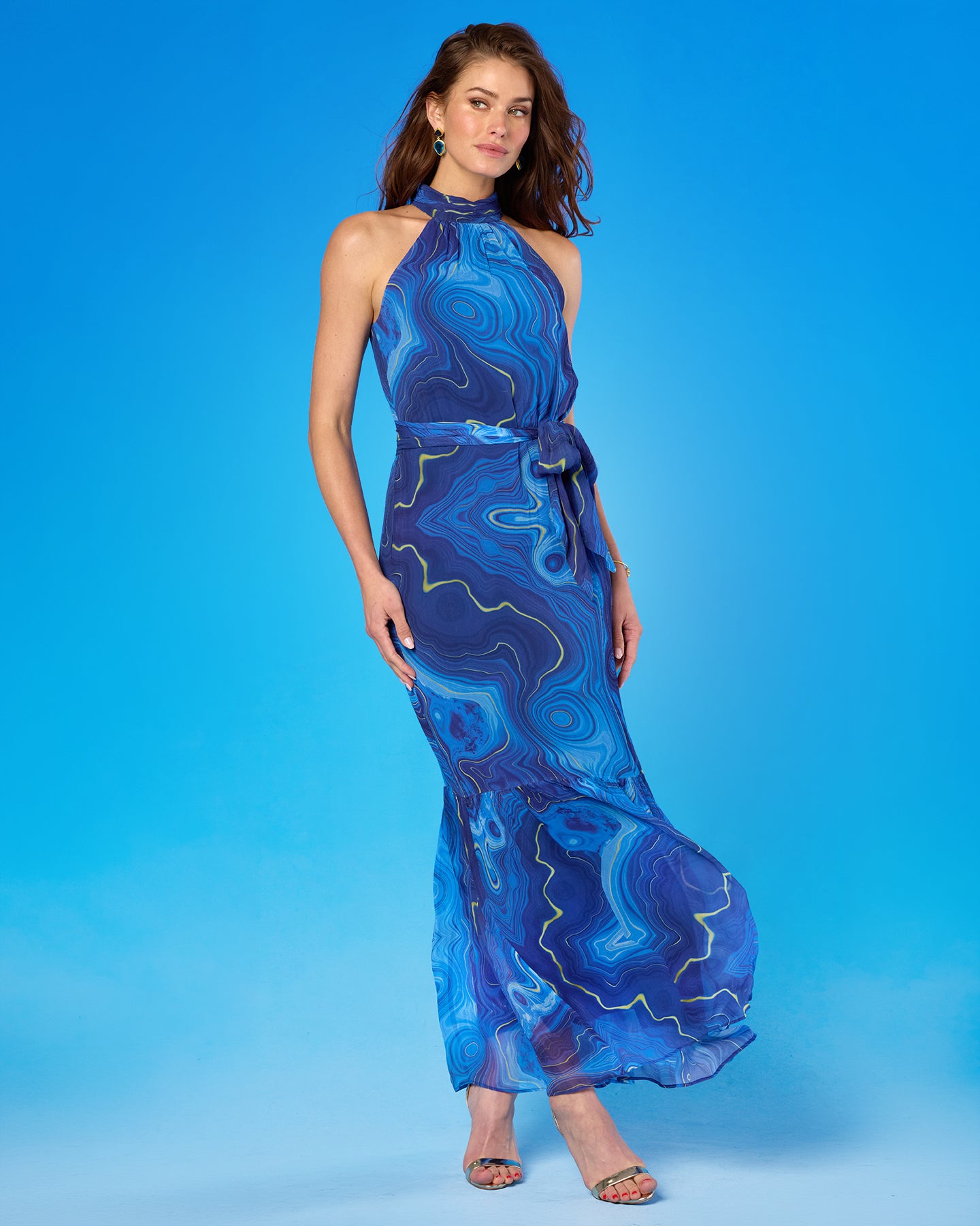 Woman wearing a blue patterned dress on a blue background