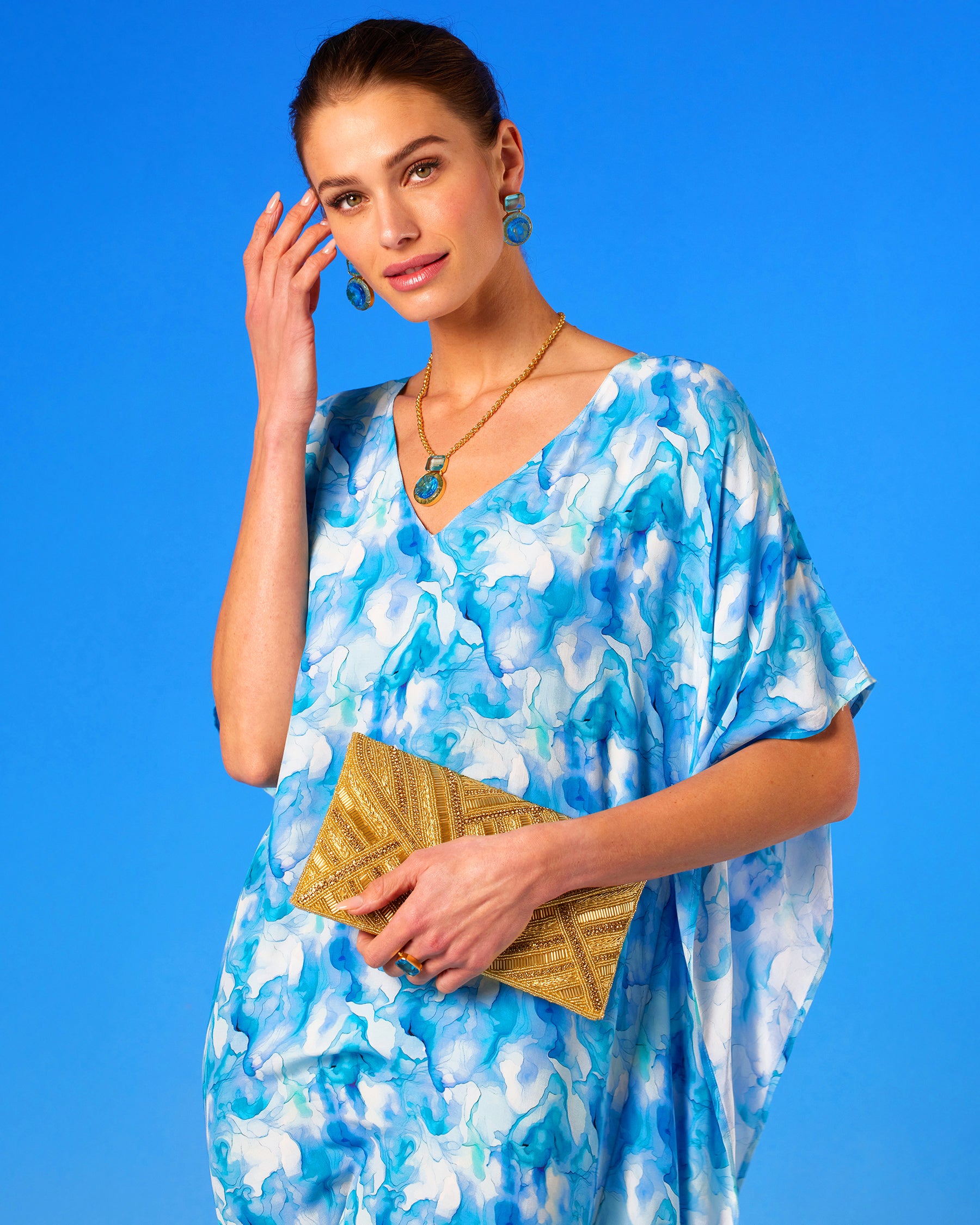 Betty Clutch in Beaded Gold worn with the Isla Kaftan in Sea Swirl Blues