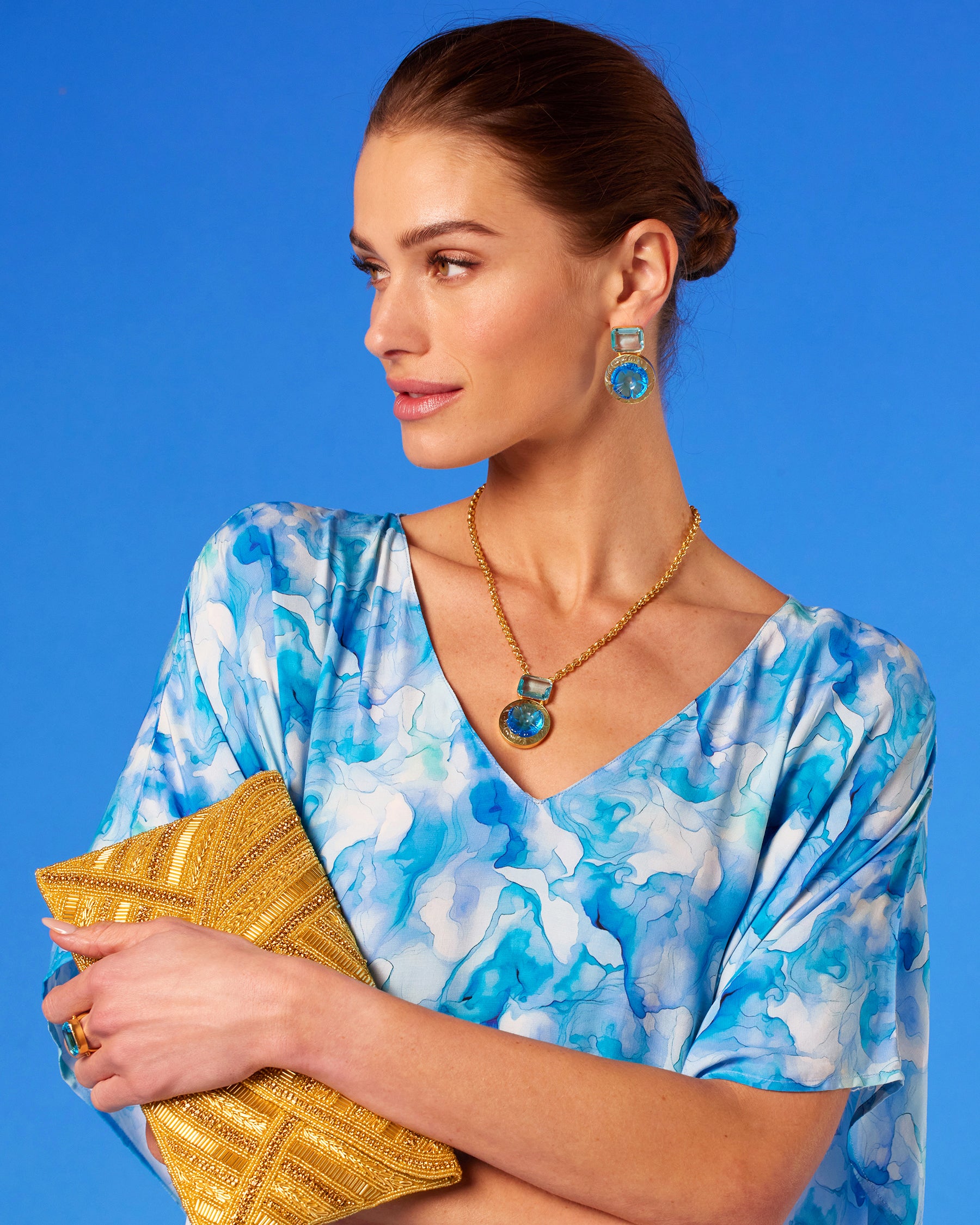 Betty Clutch in Beaded Gold worn with the Isla Kaftan in Sea Swirl Blues