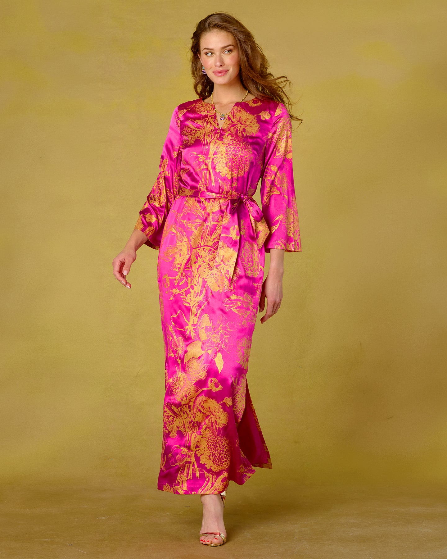 Woman wearing a pink and orange floral dress against a yellow background