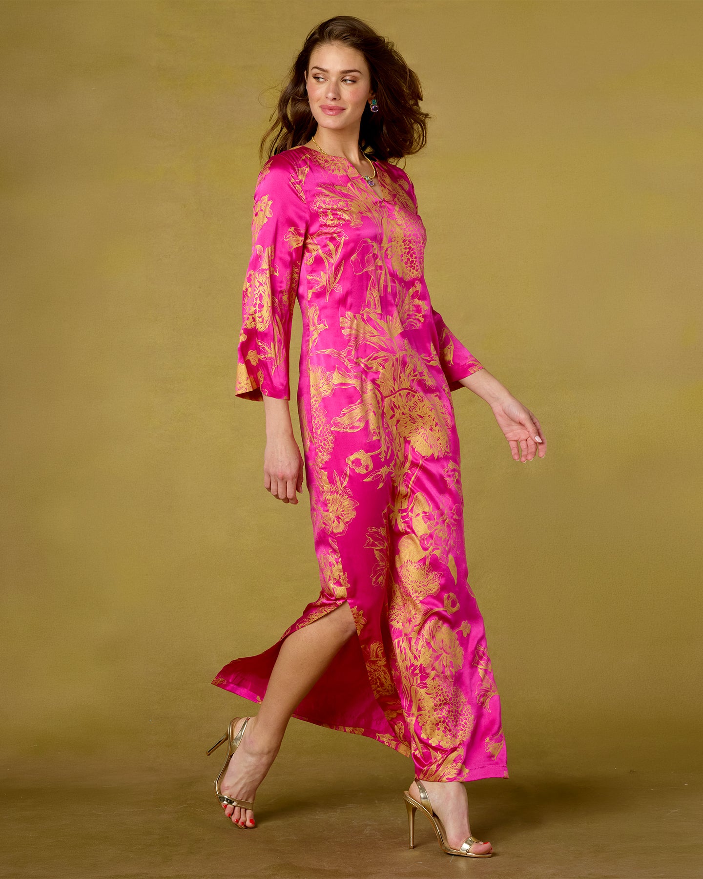 Woman wearing a pink and gold dress against a beige background