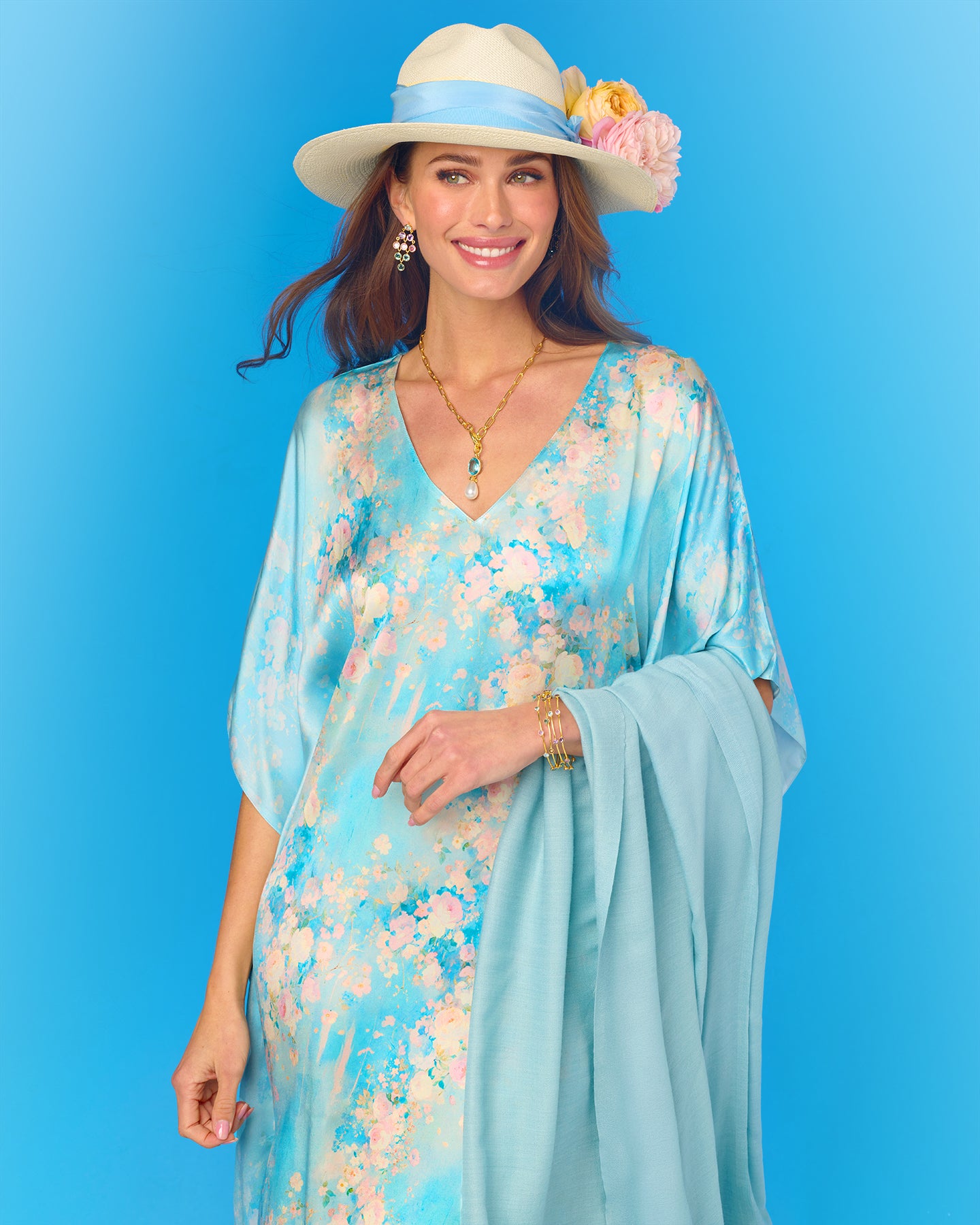 Woman wearing a floral dress and hat with a blue background