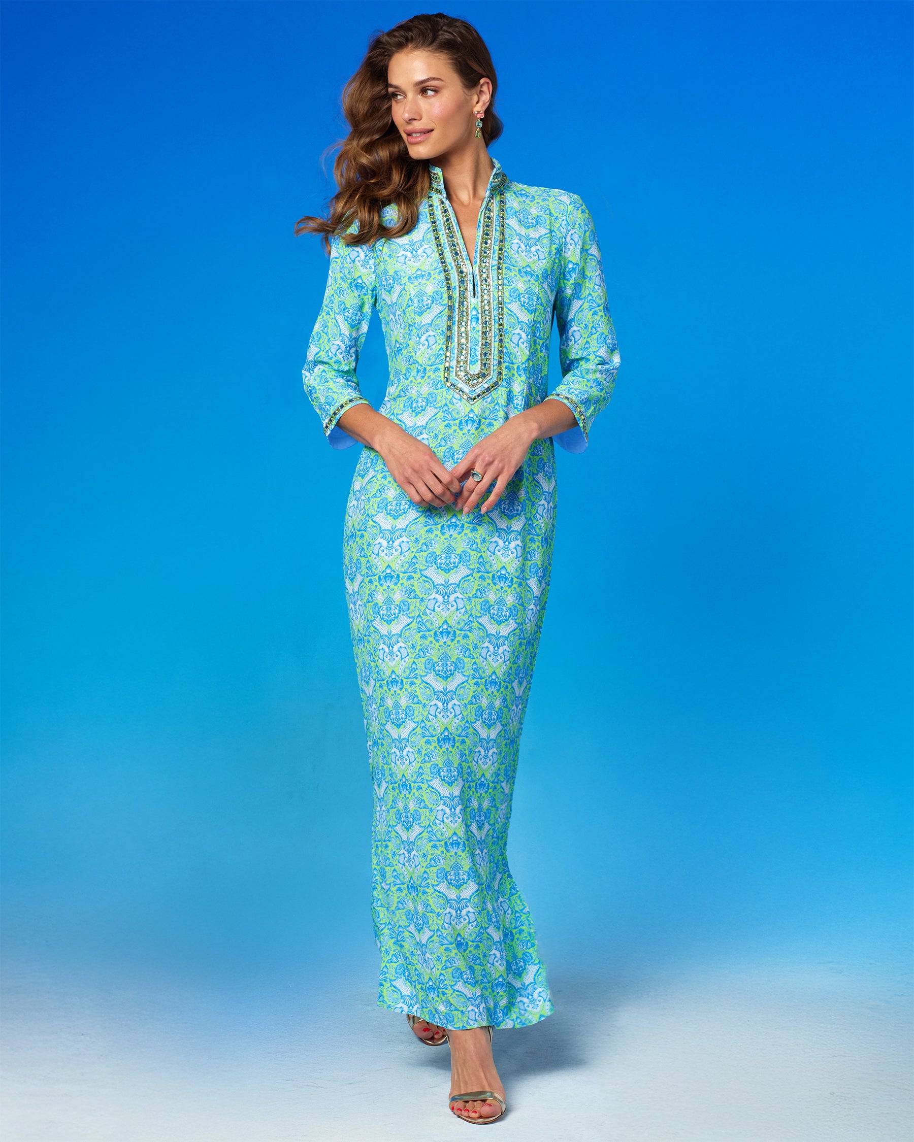 Woman wearing a blue and green patterned dress against a blue background