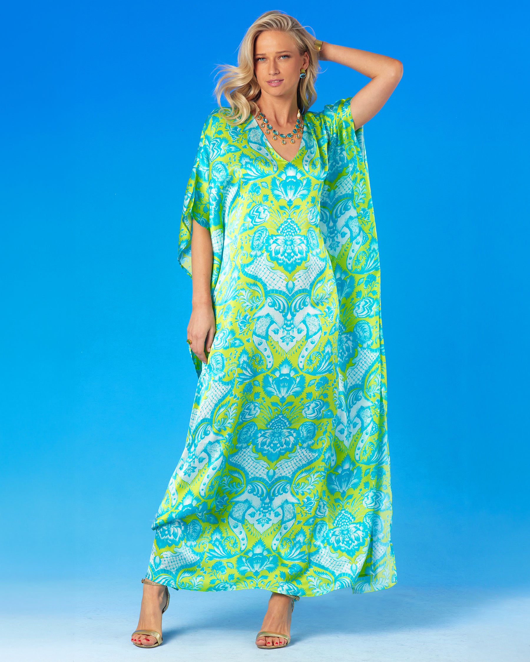 Woman with arm up wearing the Shalimar Silk Kaftan in Turquoise and Lime