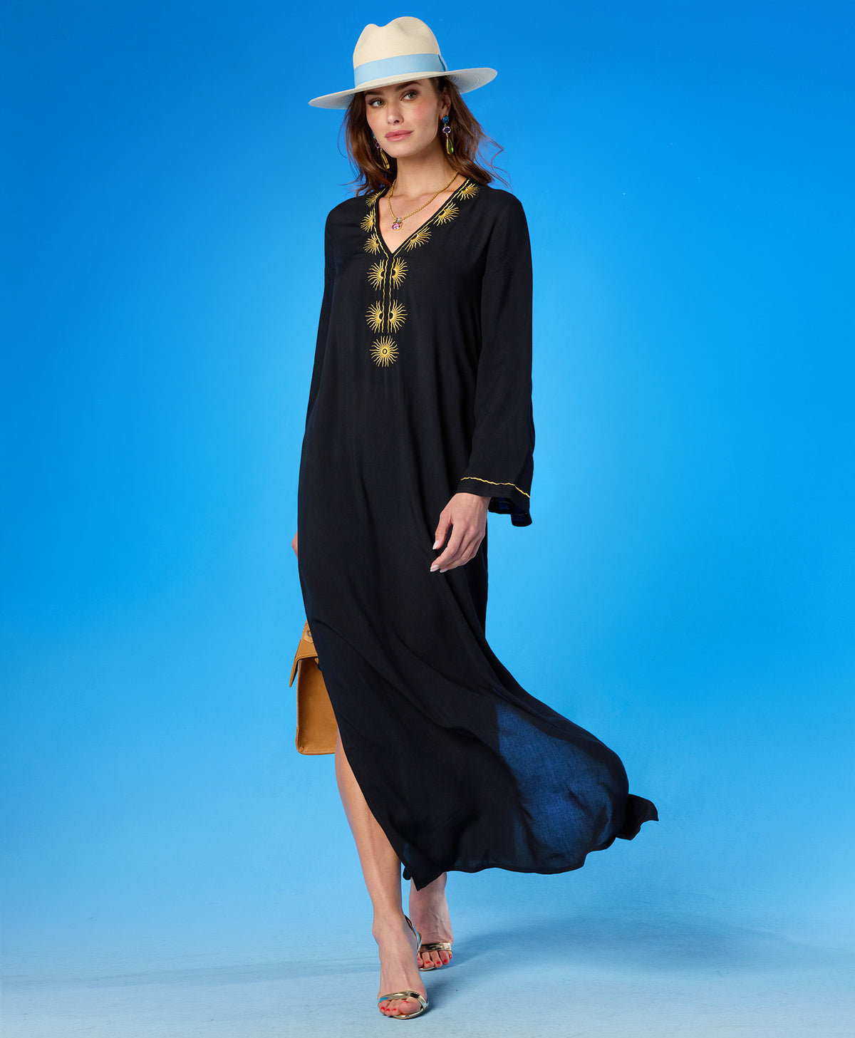 Soleil Long Kaftan Coverup Dress and in Black and Gold Embroidery blowing in the wind as the woman walks