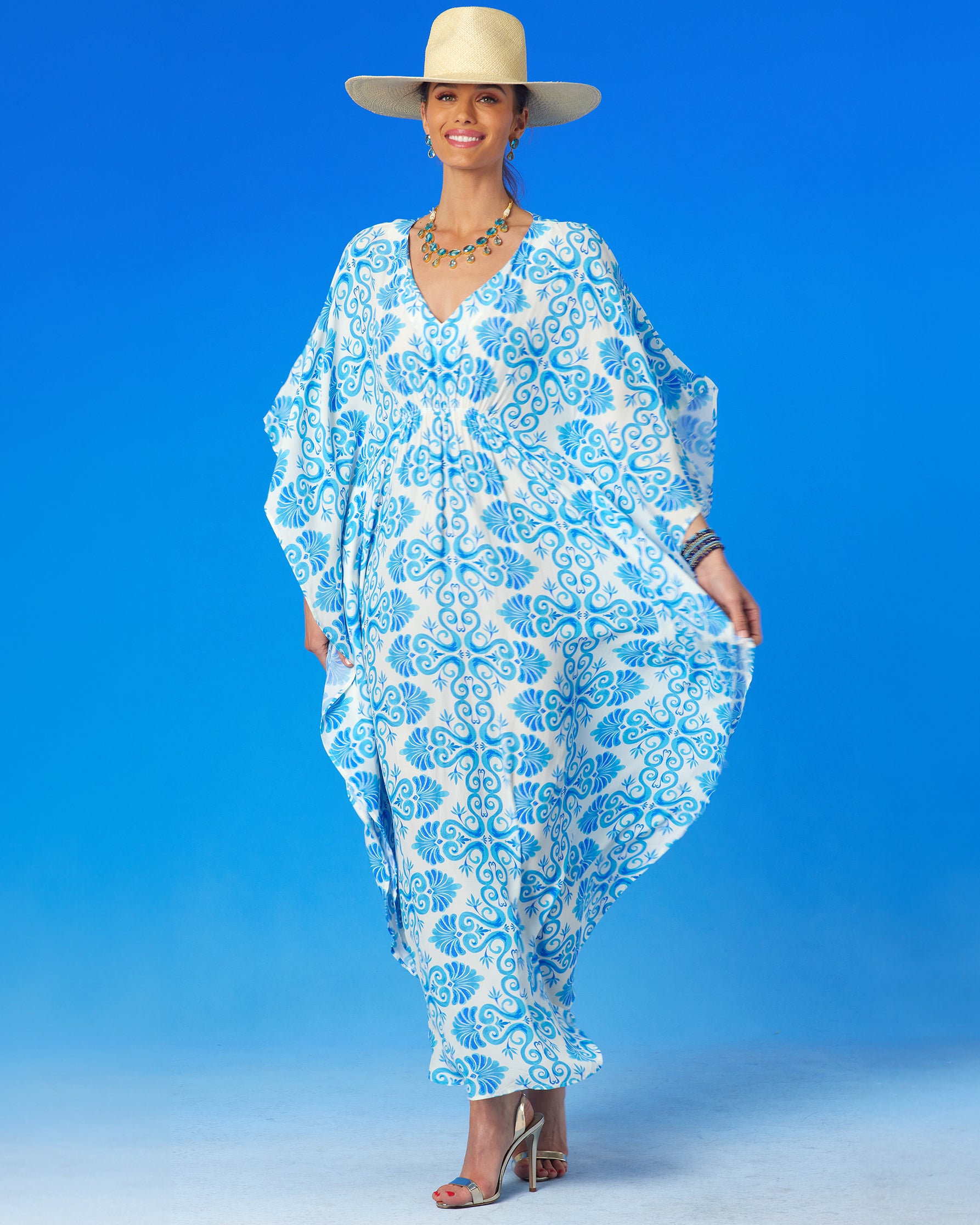 Thetis Cinched Long Kaftan in Blue and White-woman holding the kaftan by the sides and smiling